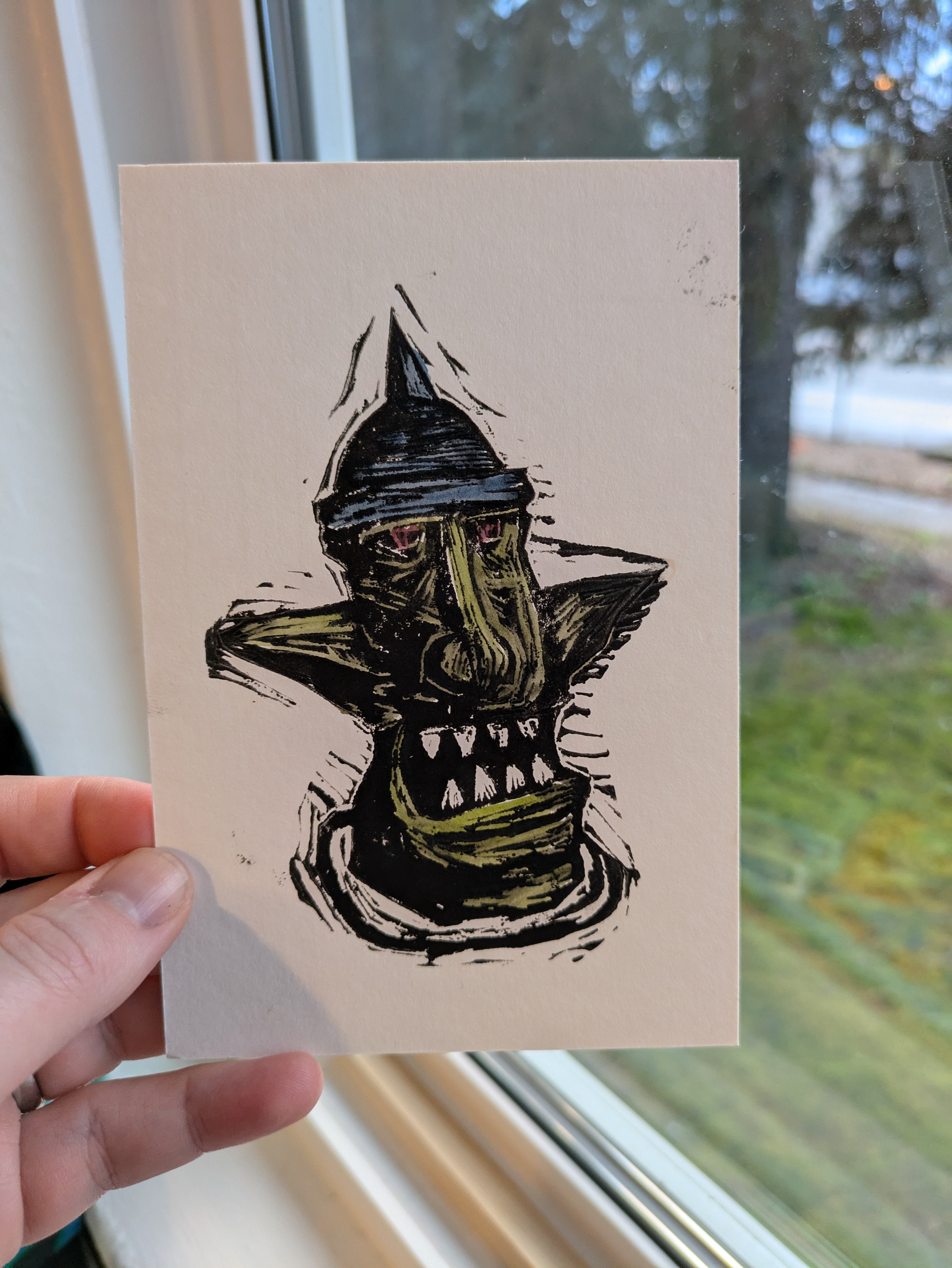 Yelling Goblin lino cut print. It has green flesh and a blue helmet
